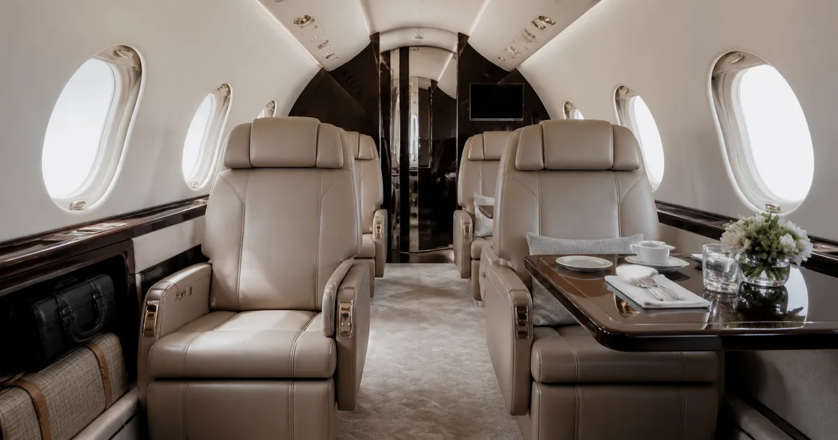 Private aircraft cabin with facing seats and side tables