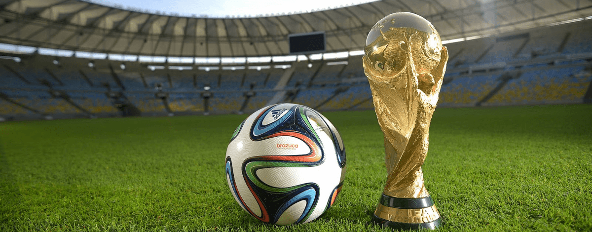 World Cup trophy and football on a stadium pitch